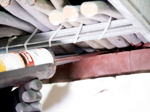 Applying Barrier FIP 1-Step Intumescent Firestop, 2-Hour UL/CAN Listed, Maroon, sag-resistant foam on cable penetrations.