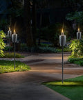Stainless Steel Outdoor Torches Set Of 2 5 Ft Citronella Oil Lamps With Fiberglass Wick and Snuffer Cap lighting a garden path