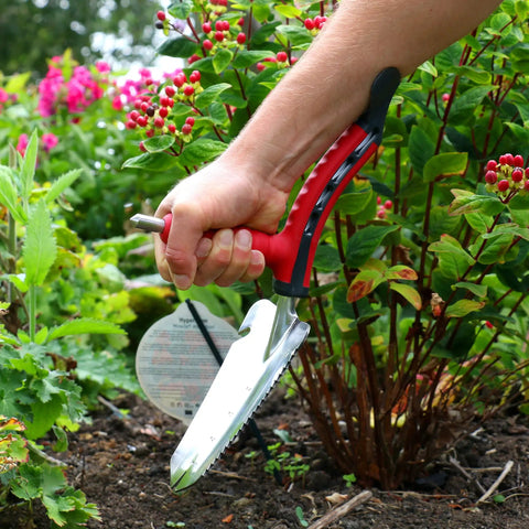 Multi Digger Dual Grip Garden Hand Trowel with Soft Touch Ergonomic Handles used in flower bed weeding task.