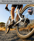 Cyclist riding mountain bike with 20mm MTB Disc Brake Adapter For 74mm Post Mount Frames on rugged trail at sunrise