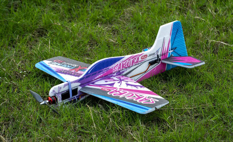 Dope Foam RC Plane Kit With 23 Inch Wingspan Sakura Plus EPP Airplane on grass, vibrant design, includes motor and servos