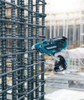 Makita DTR181ZJ 18V Brushless Rebar Tying Tool In Makpac Case fastens steel bars on construction site with precision.