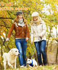 Two women walking dogs in a park with autumn leaves, wearing autumn jackets and hats.