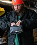 Man holding Cargo Series Weatherproof Hook-N-Haul Utility Bag With Retractable Hooks in black TPU-coated fabric
