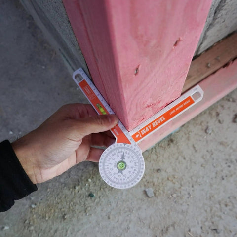 Badass 3-Way Bevel Angle Finder And Miter Protractor With Integrated Spirit Level used for measuring angles on a wood structure.