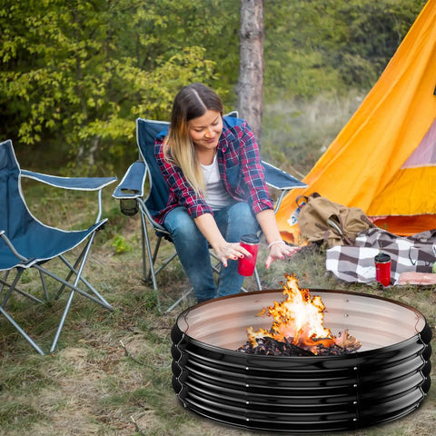 Person enjoying a bonfire in a 60 Inch Extra Large Fire Pit Ring For Outdoors Built Tough And Heavy Duty Wood Burning Pits And Outdoor Fireplaces 12 Inch Tall High Heat Resistant Galvanized Steel Fire Bowl Portable For Backyard Bonfire Patio Camping at campsite