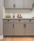 Kitchen with cabinets featuring Twelve Pack Flat Black Cabinet Cup Pulls Three Eleven Sixteenths Inch Long One And One Quarter Inch Wide.
