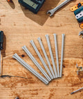 Seven essential springs from the 1/4 And 3/8 Inch Copper Tube Bender Tool Set for precise shaping on a wooden workbench.