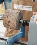 Four Prong Spring Loaded Spur Drive Center 2MT for wood lathe securing a wooden block, demonstrating strong 1 inch grip.