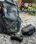 Foldable Kids Drone With 1080P HD FPV Camera Brushless Motors 2 Batteries next to a backpack on gravel