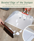 Beveled edge of 17 inch metal dustpan shown with stiff bristle brush, designed for easy debris pickup and smooth cleanup.