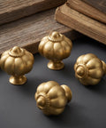 Solid Brass Cabinet Knobs And Gold Pumpkin Drawer Pulls Featuring Vintage Floral Accents For Kitchen Cupboards And Dressers Heavy Duty 6 Pack 1 1 8 Inch, four gold pumpkin cabinet knobs on a dark surface.