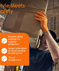 Side view of orange nitrile disposable gloves worn by warehouse worker lifting a cardboard box.