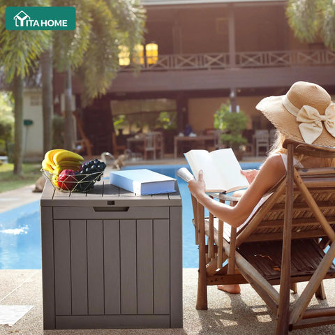 31 Gallon Outdoor Storage Deck Box With Lockable Lid Waterproof Resin Construction near poolside with fruit and book on top