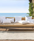 Set Of 4 18x18 Outdoor Pillow Inserts, Water Resistant Cushion Shams on patio furniture overlooking the sea, plush white pillows.