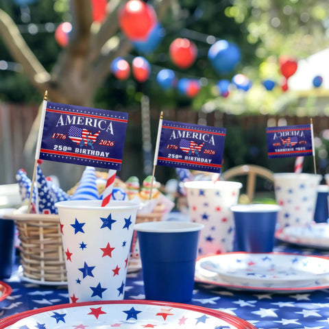 12 Pack 250th Anniversary USA Flags On Sticks 5x8 Inch Handheld Flags For 4th Of July Outdoor Decor Polyester With Wooden Sticks Party Supplies Bundle displayed on a festive table with cups and plates decorated in American flag theme, featuring balloons in the background.