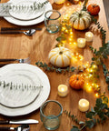 Homemory 24-pack flameless LED tea lights on a wooden table with pumpkins, garland, and string lights