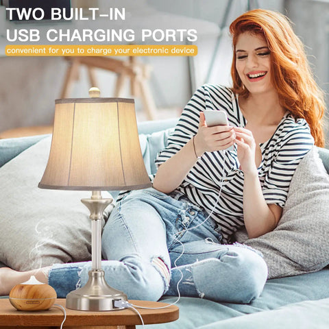 Set Of 2 Silver Touch-Activated Bedside Lamps With Dual USB Ports, woman using 3-way dimmable lamp, modern bedroom setting