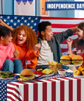 People celebrating with Patriotic Fourth Of July Tablecloth Set Two Pack 54 By 108 Inches Plastic Outdoor Party Cover with American Flag Design.