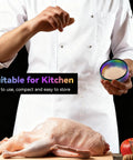 Chef using Two Inch Spice Grinder For Home Cooking, Compact Manual Herb Grinder In Bold Color over raw chicken, adds full flavor.