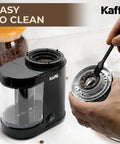 Level Up Your Coffee Game With This Heavy Duty Electric Flat Burr Grinder Crafted For Home Bars Featuring Fast Grind Adjustments And A Sleek Matte Black Housing, being cleaned with a brush.