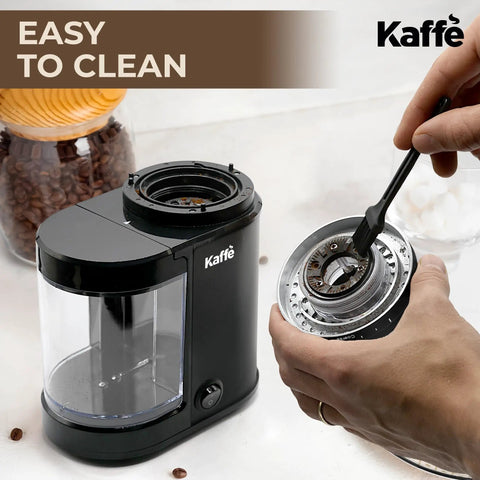 Level Up Your Coffee Game With This Heavy Duty Electric Flat Burr Grinder Crafted For Home Bars Featuring Fast Grind Adjustments And A Sleek Matte Black Housing, being cleaned with a brush.