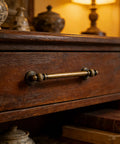 Old School Vintage Antique Brass Cabinet Pull centered on a wooden drawer in a cozy setting, brushed bronze finish 128mm center to center.