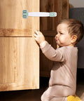 Child attempting to open a cabinet secured by a 5 Pack Kid Proof Cabinet Lock For Cabinets And Refrigerator, ABS Material, Double Press Buckles