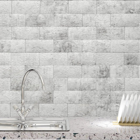 10 Pack Peel And Stick Backsplash Tiles With Realistic 3D Stone Texture In Natural White installed in a kitchen above a sink