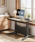 Colamy 55x28 Inch Electric Standing Desk Dual Motor Sit Stand Workstation with walnut top and heavy-duty carbon steel frame in an office setting.