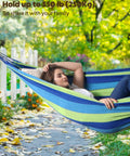 Cotton Hammock Portable Hanging Bed With Tree Straps Easy Setup Indoor Outdoor 550 Pound Capacity Dope Comfort For Backyard Camping And Travel For Ultimate Chill, featuring a woman laying in a blue and green hammock outdoors.