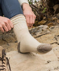 Person wearing Merino Wool Hiking Socks With Cushioned Arch Support, Moisture Wicking, Tan Color on rocky trail