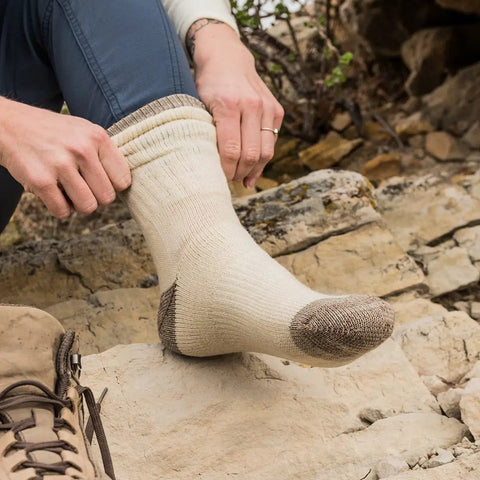 Person wearing Merino Wool Hiking Socks With Cushioned Arch Support, Moisture Wicking, Tan Color on rocky trail