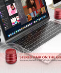Compact Waterproof Bluetooth Speaker With Big Sound next to a laptop, red mini wireless speaker for travel, stereo pairing shown