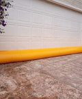 HydraBarrier Supreme Flood Barrier 12 Feet Long 20 Inches Wide 12 Inches High Water Diversion Tube in front of a garage door.