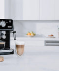 Straight Fire 15 Bar Espresso Machine With Adjustable Steam Wand And Manual Frothing System For Rich Lattes And Quick Shots In Sleek Stainless Steel Finish with latte in glass.