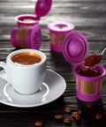Purple Reusable K Cup Pods For Coffee Nerds Who DIY Their Brews BPA Free Universal Fit For 1.0 And 2.0 Brewers next to a coffee cup
