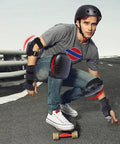 Man wearing 6 In 1 Protective Gear Set With Knee Pads Elbow Pads And Wrist Guards For Skateboarding Biking Roller Skating And Cycling Adults And Kids Durable Impact Resistant With Ventilated Foam For Comfort And All Day Safety, skating on a road, showcasing durability and safety features.