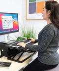 Person using Sit Stand Keyboard Tray For Desk With Height Adjustable Riser and Large 23.6x11.8 Surface at office desk