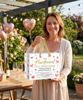 Woman holding Anniversary Gift Bag For Hubby With Greeting Card And 3 Tissue Paper Romantic Heart Theme Wrap Bag For Men in garden