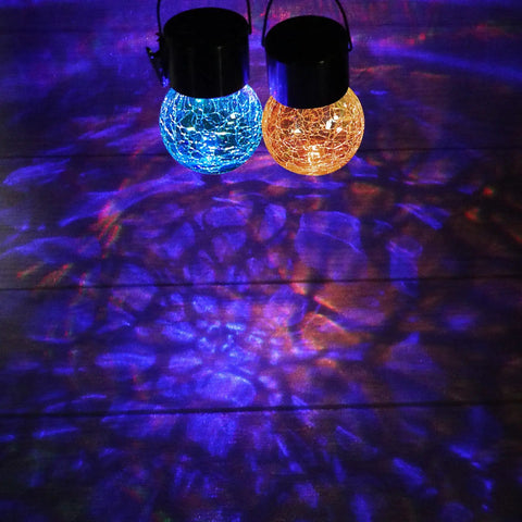 Two illuminated glass globes from 12 Pack Hanging Solar Cracked Glass Globe Lights Outdoor Waterproof Lanterns With Handle Clip No Wiring Easy Install For Garden Patio Yard Fence Tree Umbrella Holiday Decor casting colorful patterns