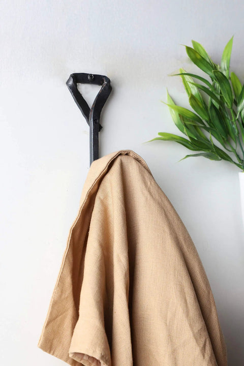 Heavy Duty Wrought Iron Coat Hook With A Distressed Bronze Look Hand Forged Wall Mount Rack Built Tough Rust Proof Construction hanging a tan coat
