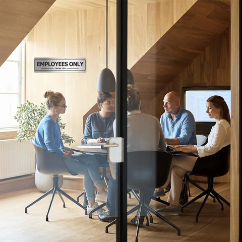 Office meeting room with clear glass door displaying Two Pack Employees Only Door Sign For Office And Business Durable Aluminum Metal Sign.