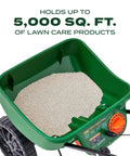 Top view of Turf Builder EdgeGuard Mini Broadcast Spreader For Lawns showing 5,000 sq ft capacity hopper filled with lawn care product