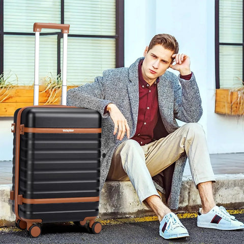 Man sitting with Velaybor lightweight 3 piece luggage set with spinner wheels, 20 inch black carry-on, durable hardside PC case.