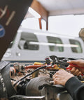 Mechanic using Pipe Gripping Pliers With Replaceable Plastic Jaws For Soft Surfaces on aircraft wiring connector, plane in background.