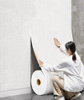 Woman installing Kick Back The Chill With Prime Thermal Wallpaper For Cold Walls Peel And Stick Heat Blocking Wall Covering.