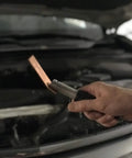 Hand holding copper welding spoon in garage for Copper Welding Spoon Set For MIG Spot Welding Three Plate Copper Paddle Backer Kit