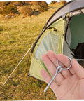 Person holding 10 Pack Tent Pole Connectors With Single Needle Ring For Quick Setup And Takedown near a camping tent.