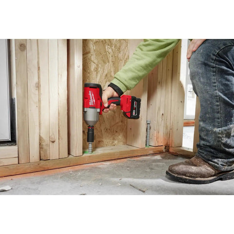 Person using Half Inch Brushless Impact Wrench With RedLink Intelligence High Torque Beast For Tough Fasteners Delivers Eight Hundred Foot Pounds Fastening Torque And One Thousand Two Hundred Foot Pounds Nut Busting Torque 18V M18 System Friction Ring Anvil on wooden frame